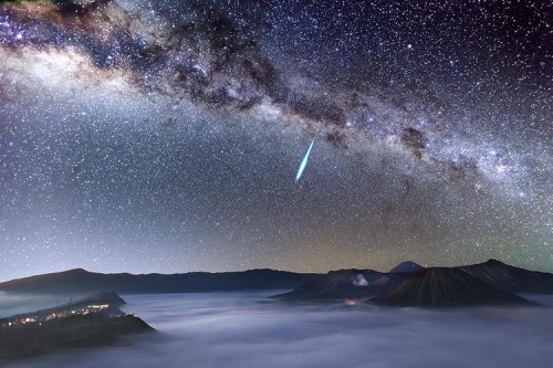 A bright meteor streaks across the magnificent night sky over the smoke-spewing Mount Bromo just one day before the peak of the Eta Aquarid meteor shower, which is caused by Halley’s Comet. Mount Bromo is one of the most well-known active volcanoes in East Java, Indonesia.
