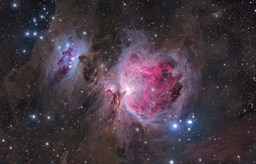 In this view of M42, more commonly known as the Orion Nebula, the photographer has emphasized the delicate veils of dust surrounding the more familiar gleaming heart of the nebula. The image highlights the structure of the object, giving a sense of vast cavities filled with pink hydrogen gas and the blue haze of reflected starlight.